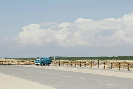 Blue Volkswagen campervan parked up next to the beach.