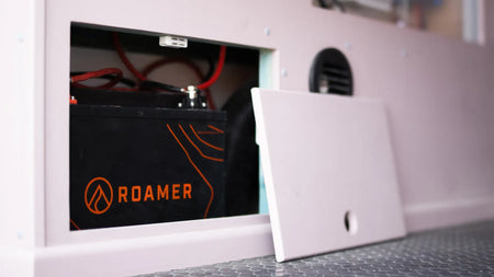 A Roamer battery installed into the back of a campervan. Clean, neat electrical system hidden away in a white cupboard.
