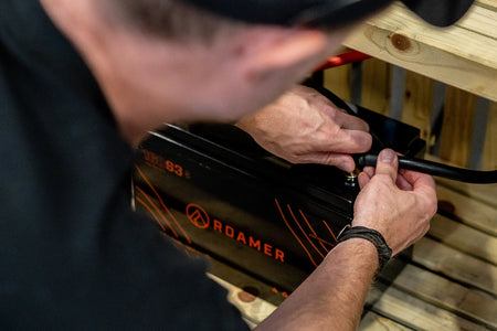 A member of the Roamer team connecting a cable to a Roamer smart battery.
