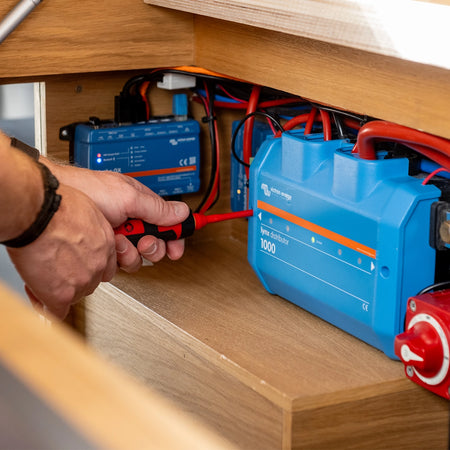 A member of the Roamer team fixing a Roamer and Victron electrical system.