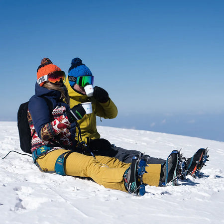 Kate and Steve from Roamer Batteries on the top of a mountain in Chamonix drinking coffee from Roamer mugs.