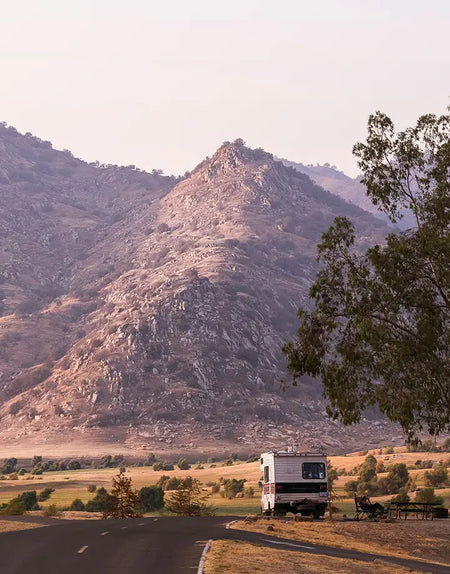 A motorhome parked up in a mountain landscape.