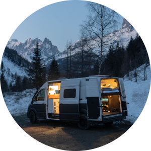 A campervan parked up at night time with its lights on - inside a circle
