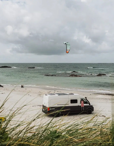 Hannah Whiteley kitesurfing in Scotland with Roamer's campervan.