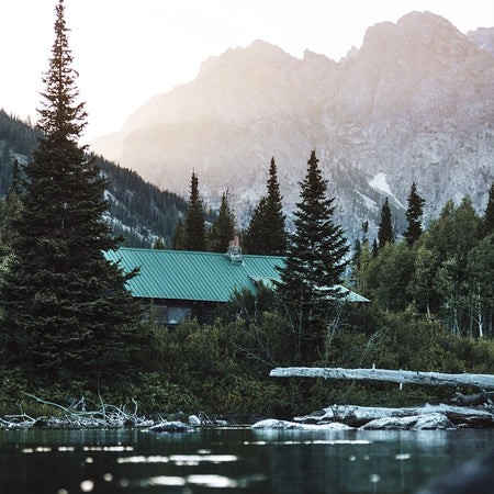 Off grid home next to a lake and mountains.