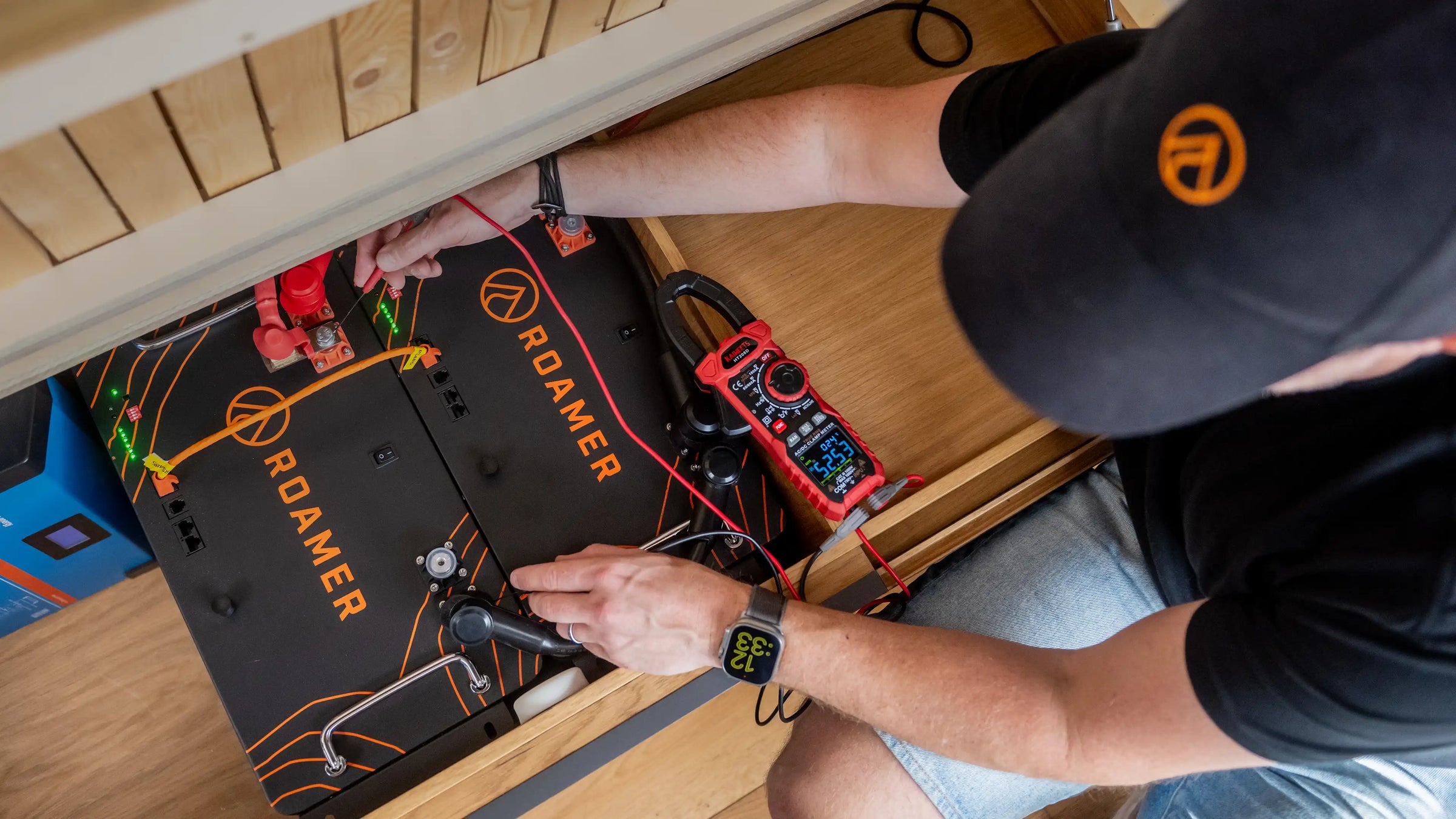 Two Roamer home batteries situated under the sofa in Roamer's Torsus campervan. Steve from Roamer checking their status.
