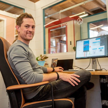 Steve from Roamer batteries smiling as he works from his desk in the Roamer office.