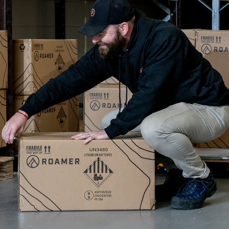 Andrew from Roamer batteries opening a Roamer branded brown box