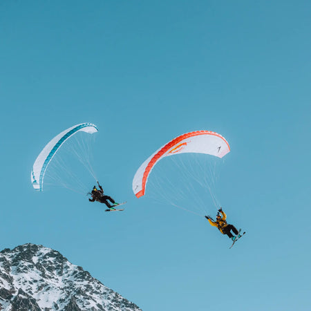 Professional speedriders Valentin Delluc and Ugo Gerola flying over the mountains in Chamonix.